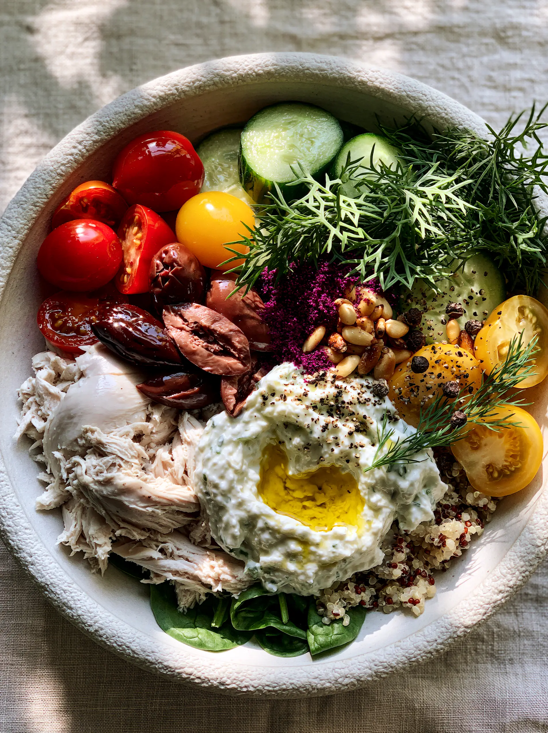 Close up overhead shot of a Mediterranean power bowl featuring heirloom tomatoes and kalamata olives, ideal for summer dinners.