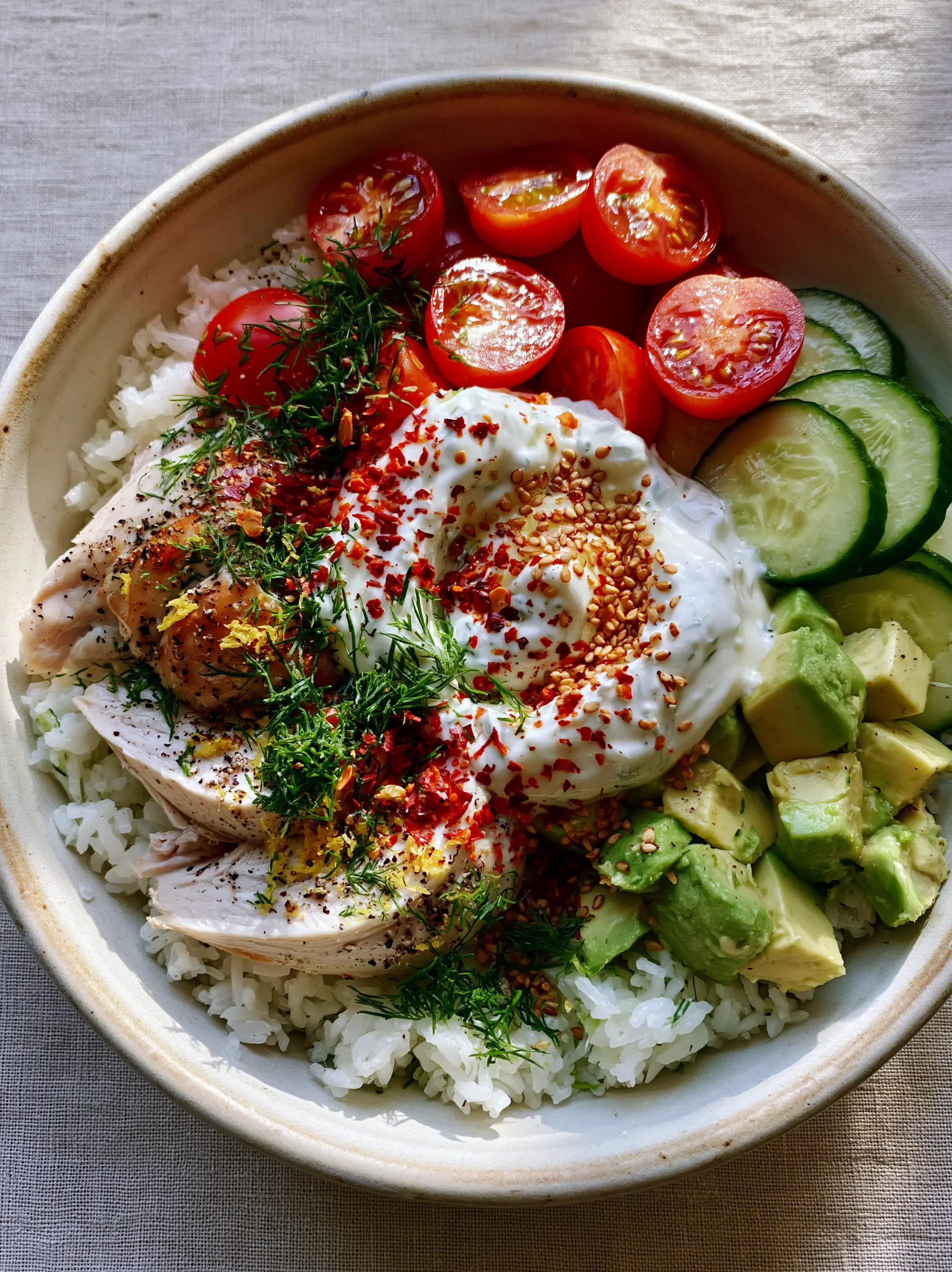 Top-down view of a Mediterranean Chicken Power Bowl on a cream ceramic plate. (Easy Summer Dinners)