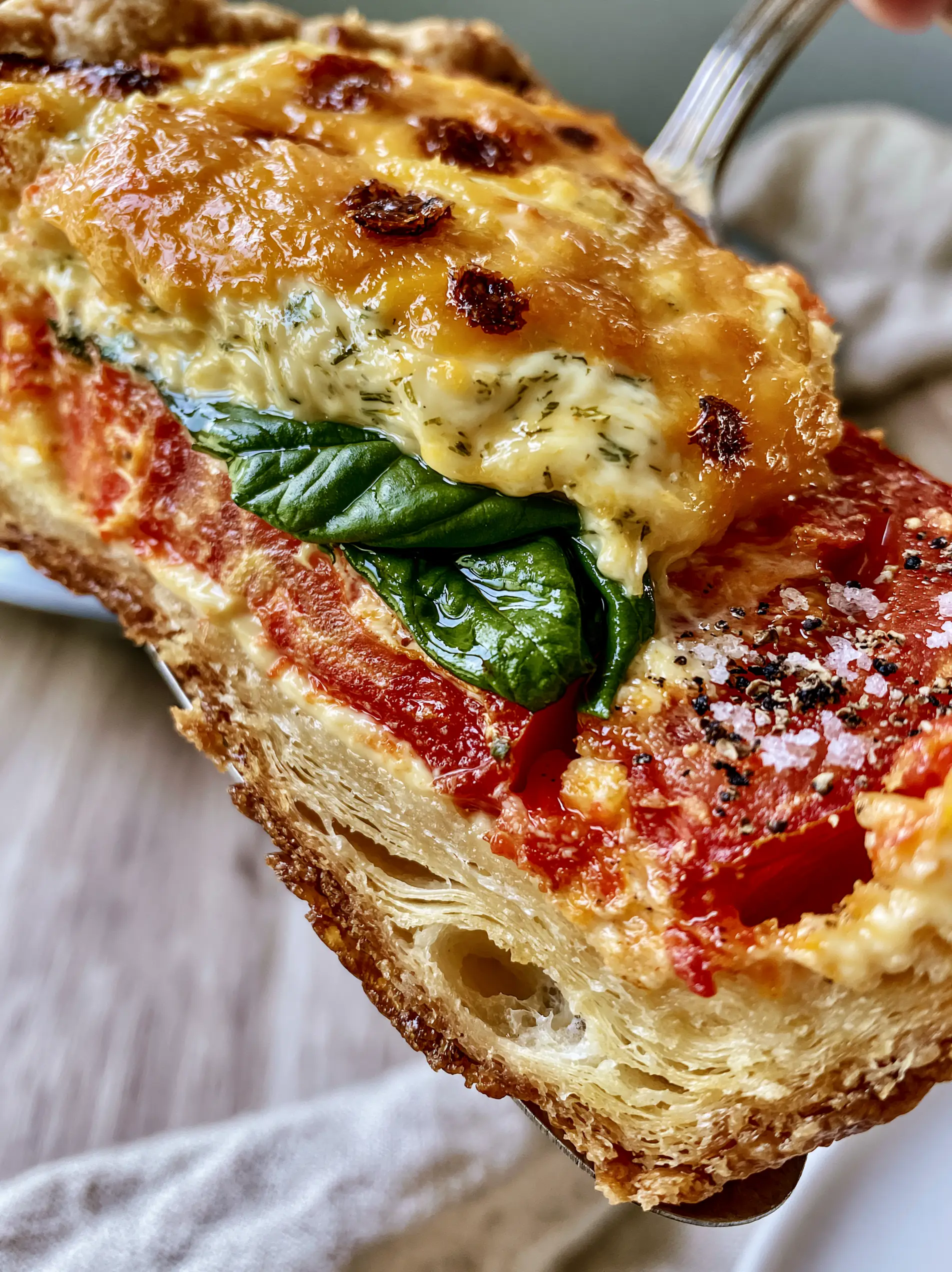 Close-up cross-section of Southern Tomato Pie showing flaky pastry air pockets and juicy red tomato slabs.